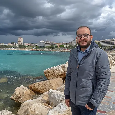 Hombre sonriente junto al mar, preparándose para el examen náutico del curso PER online
