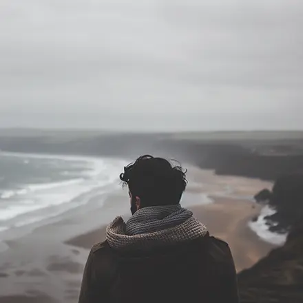 Joven en un acantilado con vistas al mar, tras haber superado el curso teórico PER online